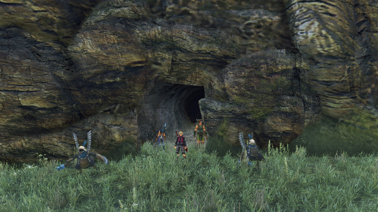 Tirkins guard the entrance to a small cave beneath a rocky cliff.
