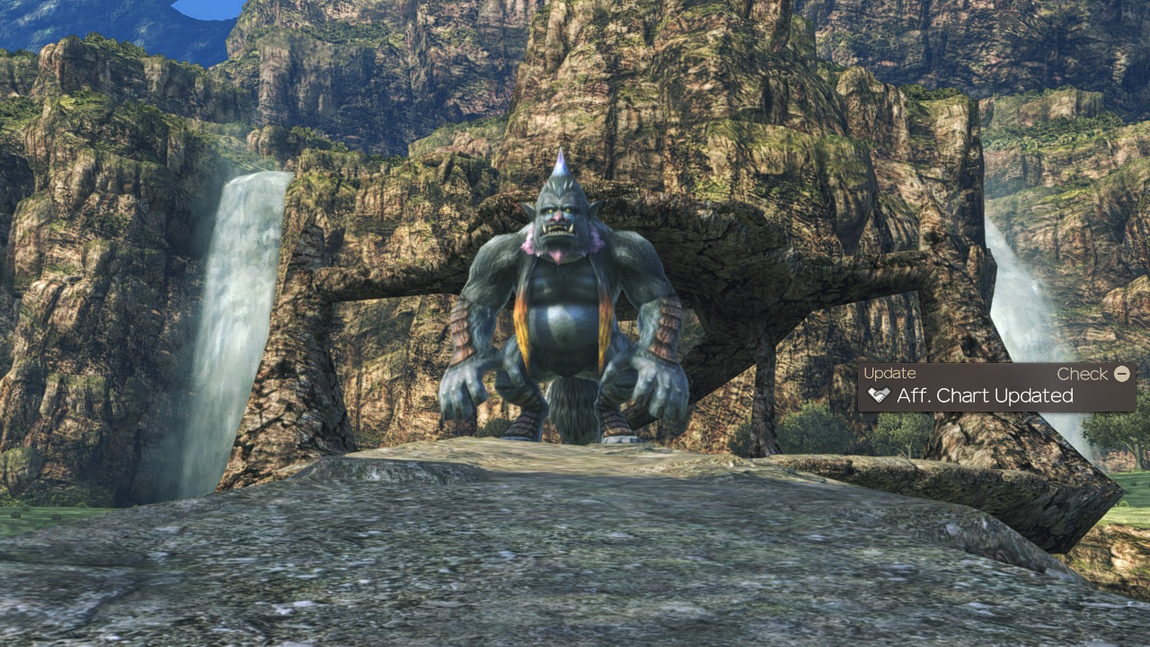 A large Gogol stands on a rocky ledge with waterfalls behind it.